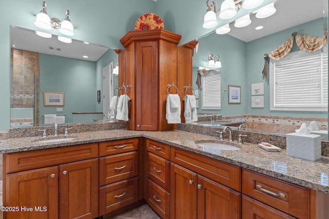 full bathroom with double vanity, visible vents, and a sink
