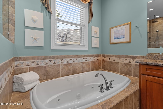 bathroom featuring vanity, tile patterned floors, and a tub with jets