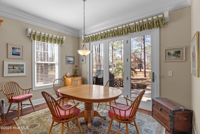 dining space with wood finished floors, baseboards, and ornamental molding