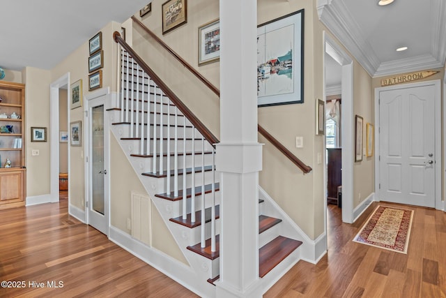 foyer with stairway, wood finished floors, baseboards, recessed lighting, and ornamental molding