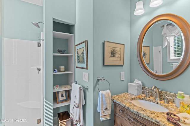 bathroom featuring a shower and vanity