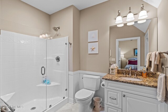 full bath with vanity, a wainscoted wall, a shower stall, toilet, and connected bathroom