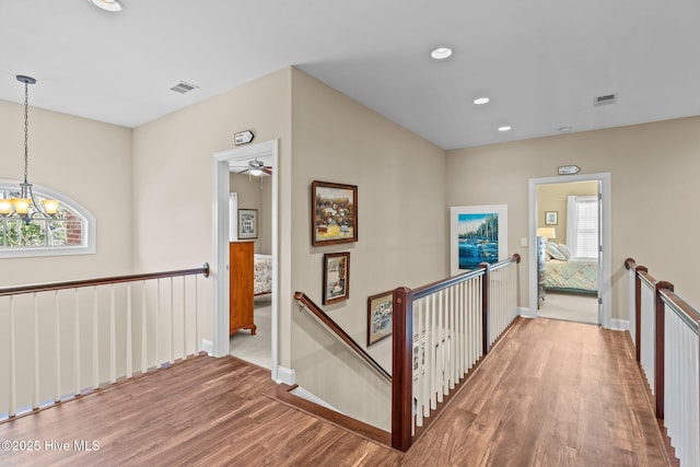corridor featuring an upstairs landing, plenty of natural light, and wood finished floors