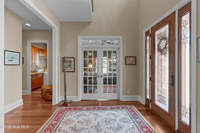 entrance foyer featuring french doors, baseboards, a ceiling fan, and wood finished floors