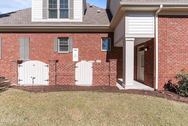 6790 Waterstone Xing SW, Ocean Isle Beach, NC 28469 - rear view of property featuring brick siding, a lawn, and a shingled roof