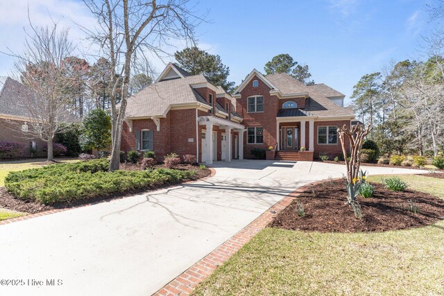 6790 Waterstone Xing SW, Ocean Isle Beach, NC 28469 - view of front of property featuring driveway, brick siding, an attached garage, and a shingled roof