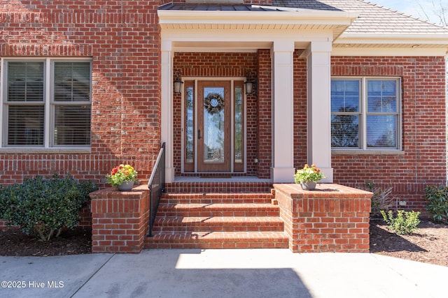 entrance to property featuring brick siding