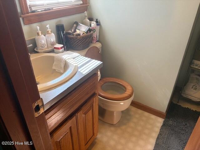 bathroom with tile patterned floors, baseboards, toilet, and vanity