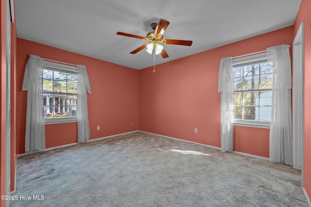 empty room featuring a textured ceiling, carpet flooring, and ceiling fan