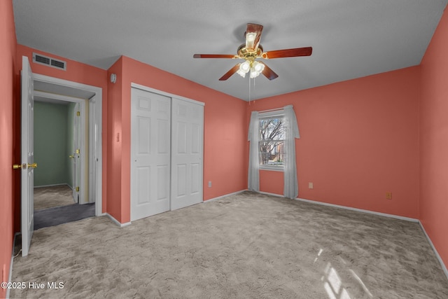 unfurnished bedroom with visible vents, baseboards, carpet, a closet, and a ceiling fan