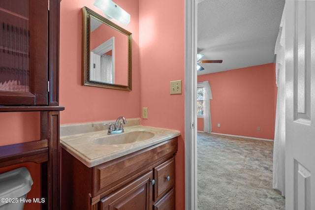 bathroom featuring baseboards, ceiling fan, and vanity