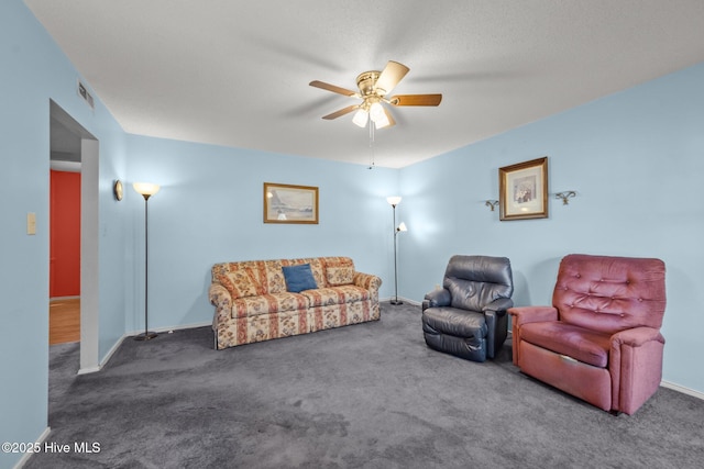 carpeted living area featuring baseboards, visible vents, and ceiling fan