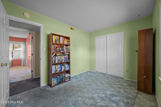 unfurnished bedroom with a closet, baseboards, carpet, and visible vents