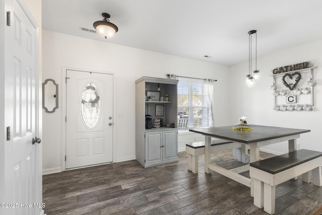 dining area featuring baseboards, visible vents, and dark wood-style flooring