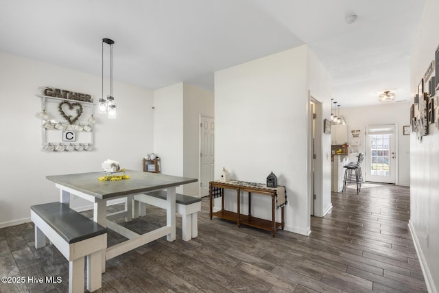 dining area with dark wood-type flooring and baseboards