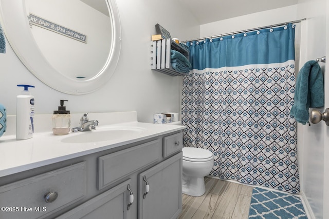 full bathroom featuring a shower with shower curtain, toilet, vanity, and wood finished floors