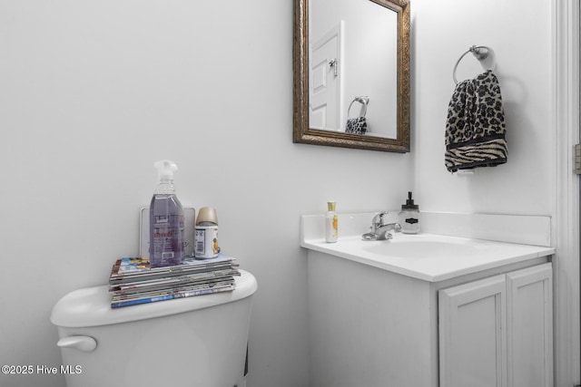 half bath featuring vanity and toilet