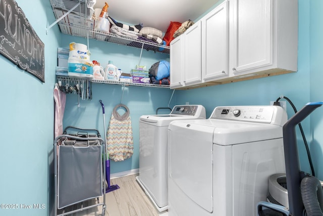 washroom with washer and dryer, cabinet space, and wood finished floors