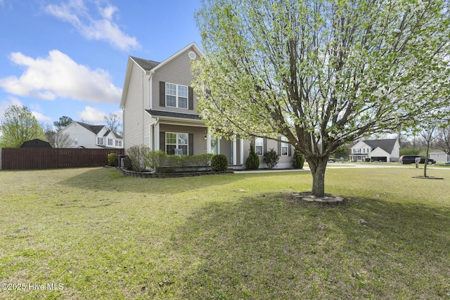 view of front facade with a front lawn and fence