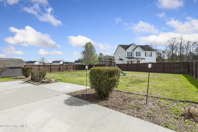 view of yard with a patio area, a playground, and a fenced backyard