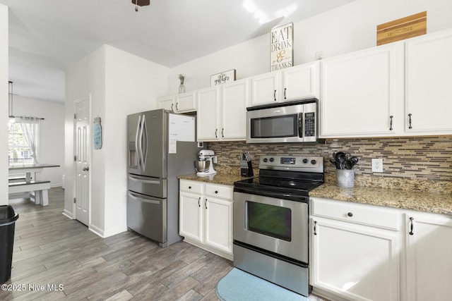 kitchen featuring tasteful backsplash, white cabinets, and stainless steel appliances