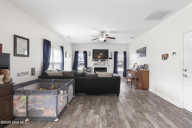 living area with visible vents, plenty of natural light, ceiling fan, and wood finished floors