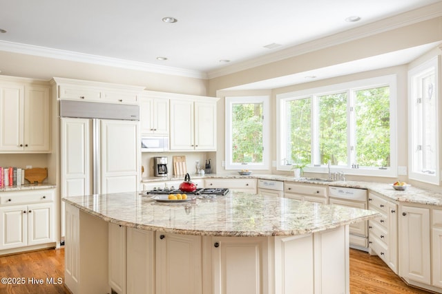 1806 Odyssey Dr, Wilmington, NC 28405 - kitchen with a center island, white appliances, light stone counters, light wood-type flooring, and crown molding