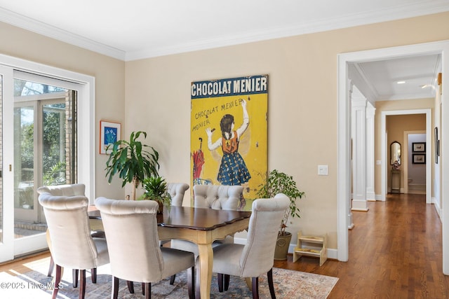 dining area featuring baseboards, wood finished floors, and crown molding