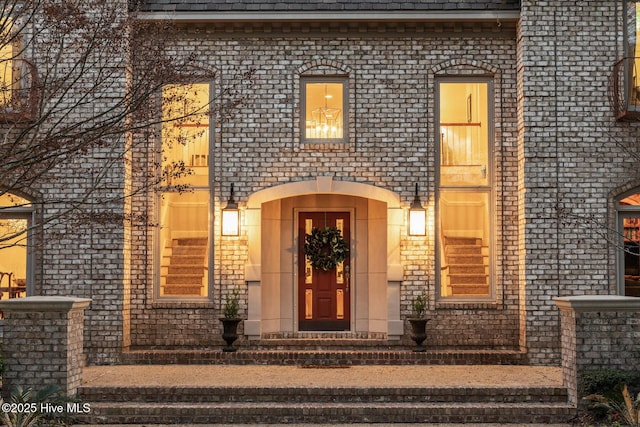 view of exterior entry featuring brick siding