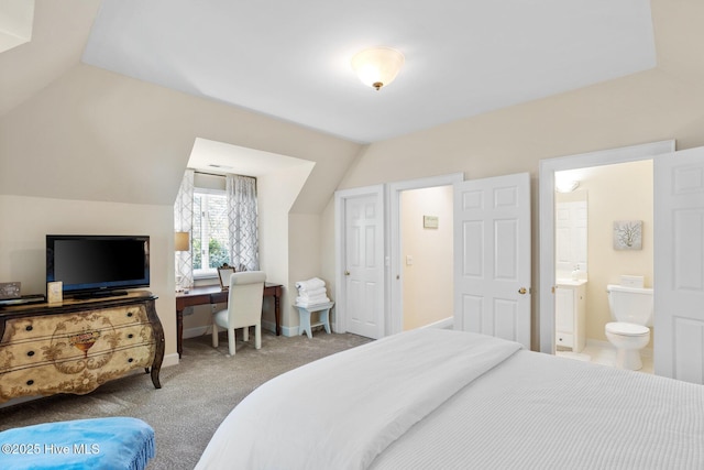 bedroom with lofted ceiling, carpet floors, baseboards, and connected bathroom