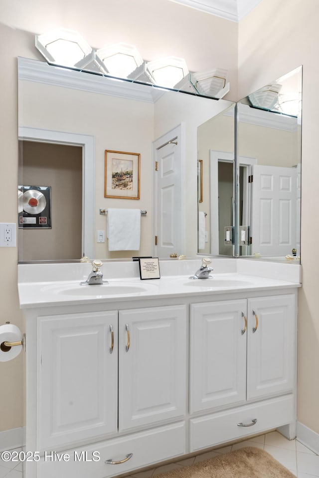 bathroom featuring tile patterned flooring, double vanity, crown molding, and a sink