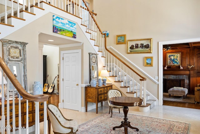 entryway featuring ceiling fan, stairs, and a towering ceiling