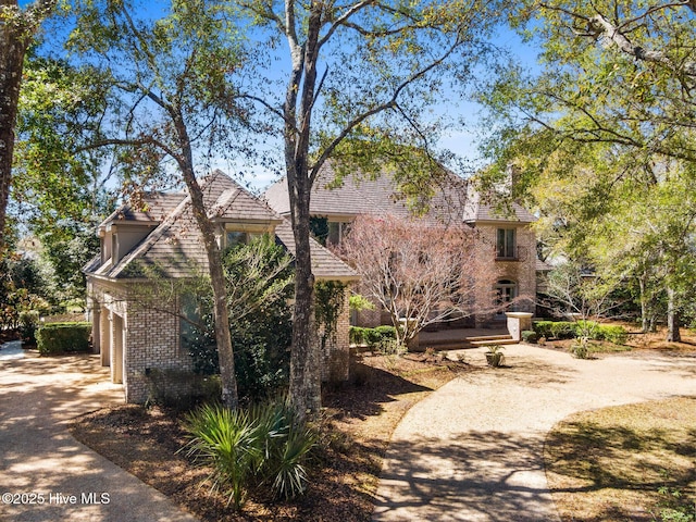 view of front of property featuring driveway, brick siding, and a garage