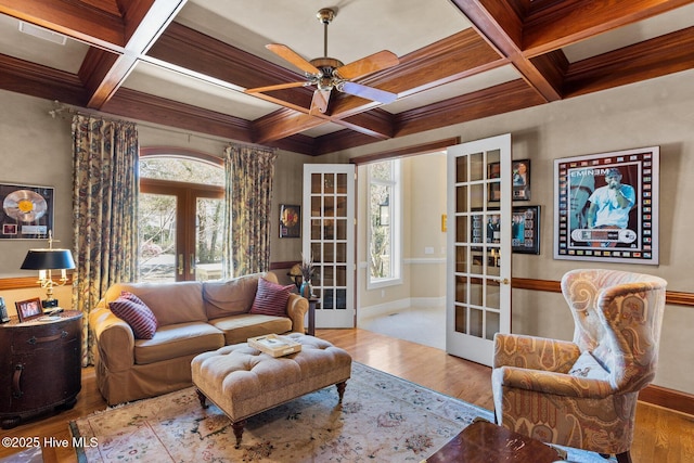 living area with coffered ceiling, wood finished floors, a ceiling fan, french doors, and baseboards
