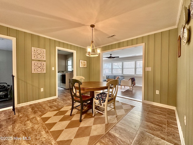 dining room with visible vents, washing machine and dryer, crown molding, baseboards, and ceiling fan