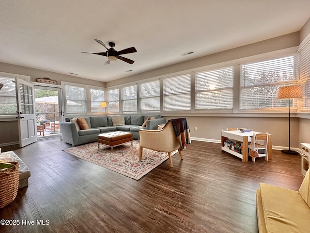 living room with visible vents, baseboards, a ceiling fan, and wood finished floors