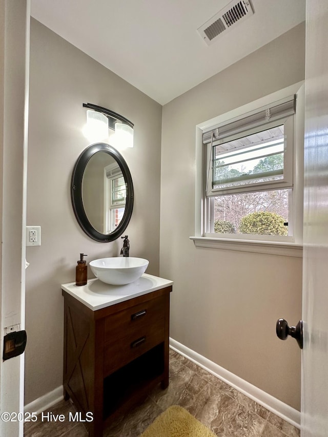bathroom featuring baseboards, visible vents, and vanity