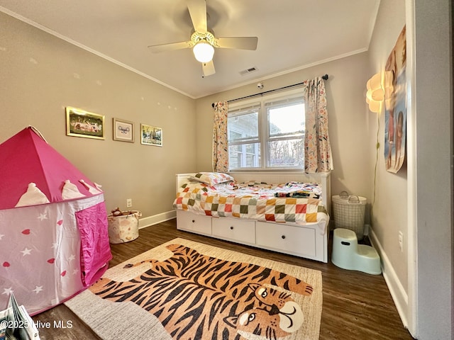 bedroom with baseboards, crown molding, wood finished floors, and visible vents