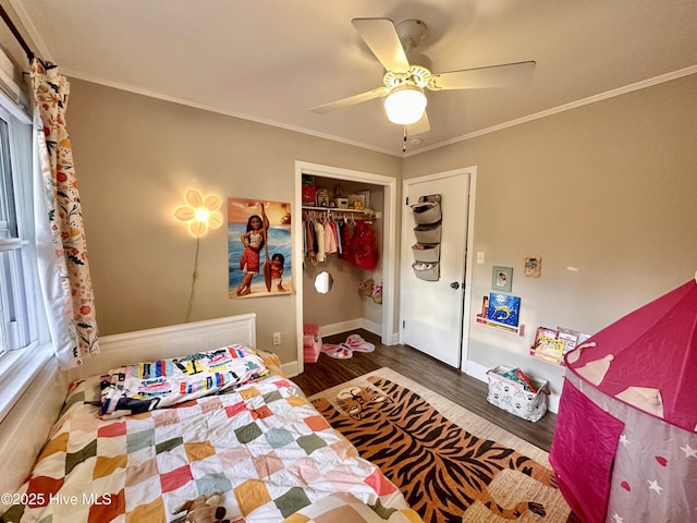 bedroom with wood finished floors, ornamental molding, a closet, baseboards, and ceiling fan