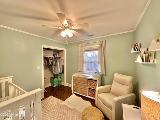 bedroom featuring baseboards, visible vents, wood finished floors, a closet, and ornamental molding
