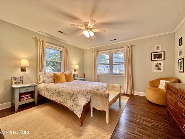 bedroom featuring dark wood-type flooring, visible vents, crown molding, and baseboards