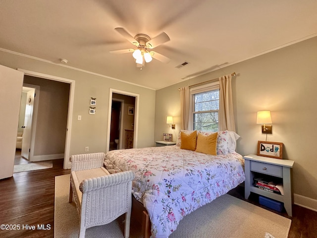 bedroom with baseboards, visible vents, wood finished floors, ceiling fan, and crown molding