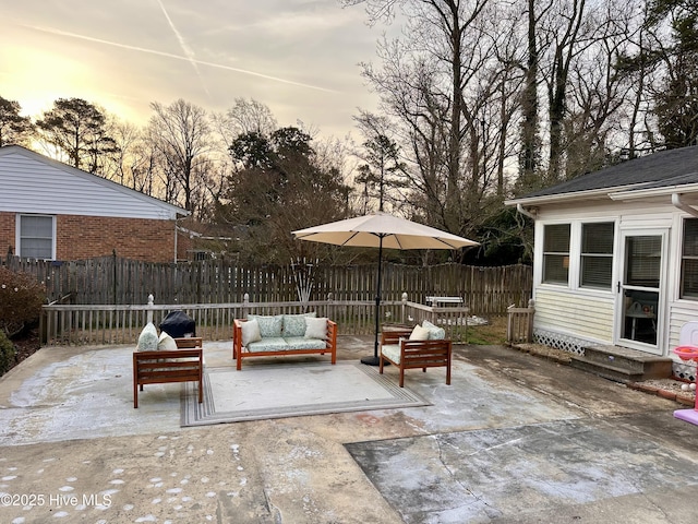 patio terrace at dusk featuring fence, entry steps, and an outdoor hangout area