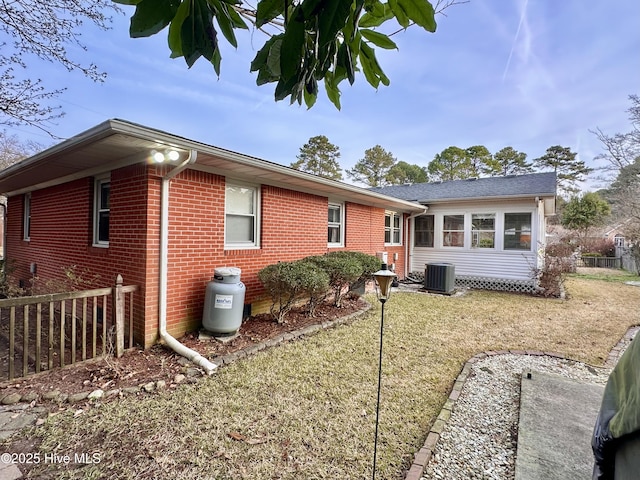 back of property featuring fence, brick siding, and cooling unit