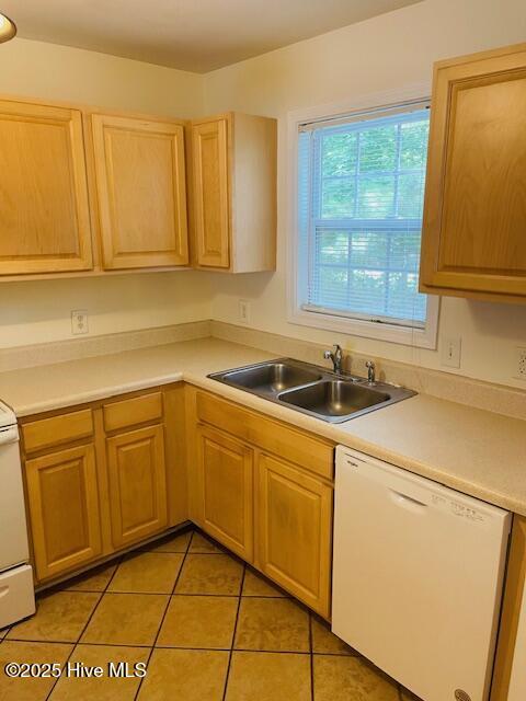 305 Comanche Trl, Havelock, NC 28532 - kitchen featuring white dishwasher, a sink, light tile patterned flooring, light brown cabinetry, and light countertops