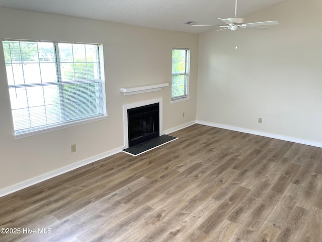 142 Witten Cir Unit A, Havelock, NC 28532 - unfurnished living room featuring ceiling fan, baseboards, a fireplace with raised hearth, and wood finished floors