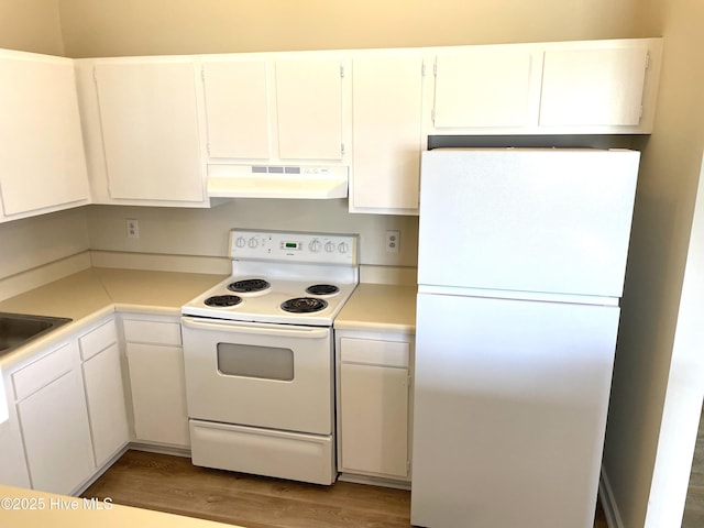 142 Witten Cir Unit A, Havelock, NC 28532 - kitchen with under cabinet range hood, white appliances, light countertops, wood finished floors, and white cabinetry
