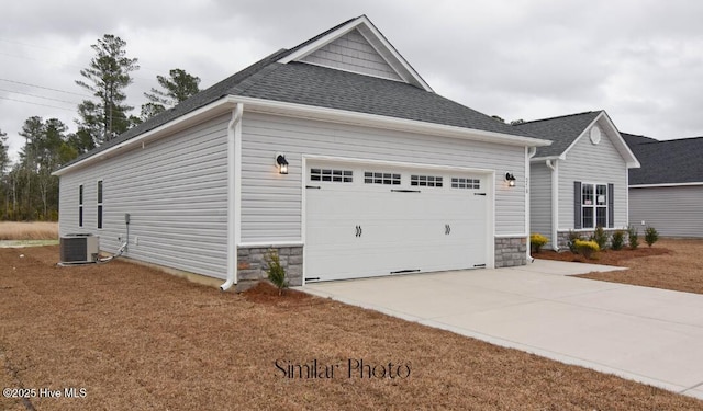 761 Regiment Rd, Jacksonville, NC 28546 - view of home's exterior featuring an attached garage, stone siding, driveway, central AC, and a shingled roof