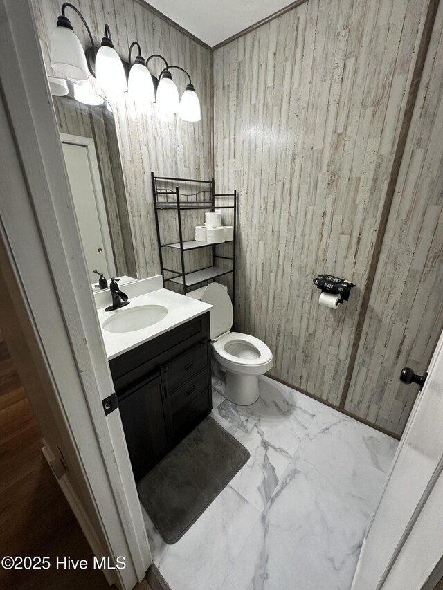 13280 Blues Farm Rd, Laurinburg, NC 28352 - half bath featuring wooden walls, marble look tiles, vanity, and toilet