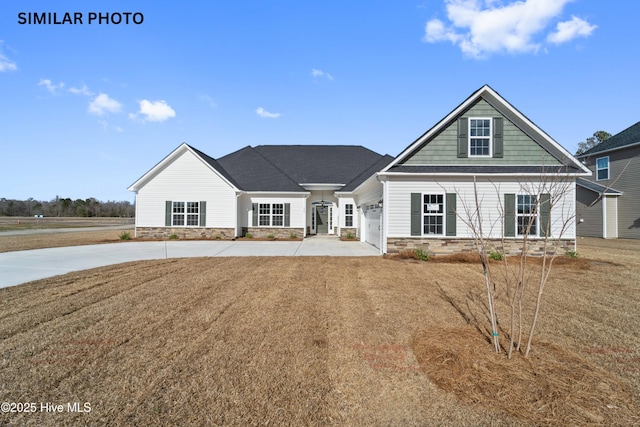 284 Water Wagon Trl, Jacksonville, NC 28546 - view of front of house featuring stone siding, driveway, a front lawn, and an attached garage